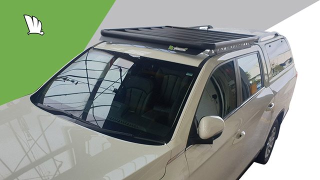 Front corner elevated view of the SsangYong Musso 2021 with a Wedgetail rack installed on the cabin roof showing the super strong platform with five cross bars, the wind deflector on the front and the one piece mounting rails.